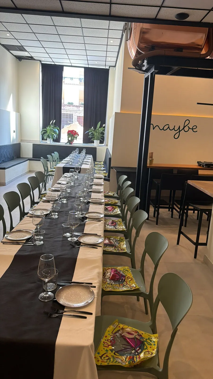 Mesa larga preparada para una celebración en Maybe